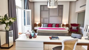 großer wohnraum der hemingway suite im luxushotel in havanna mit weißen möblen und pinkfarbenen soffelementen hellen den gesamten raum auf