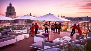 kubanische liveband auf dem dach des luxushotels mit eigenem pool und gemütlichen lounge sesseln mit der historischen stadt havanna im hintergrund bei sonnenuntergang