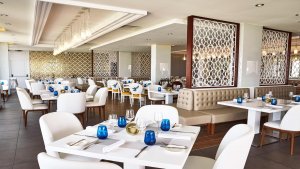 helles restaurant mit gedeckten tischen und weißen postern im edlen abmiente des luxushotels manzana