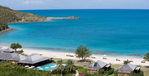 blaues meer und weisser sandstrand im hermitage bay luxus resort in antigua karibik