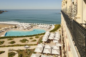 blick von der terrasse auf den schönen pool des hotel du palais und den strand der atlantikküste mit sonnenschirmen und liegen