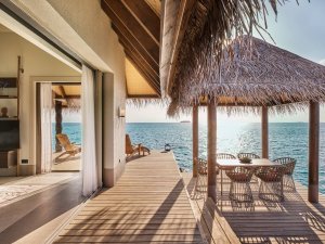 blick auf die sonnenterrasse einer villa auf dem indischen ozean mit gemütlichen sitzecken und kleinem pavilon bei sonnenaufgang