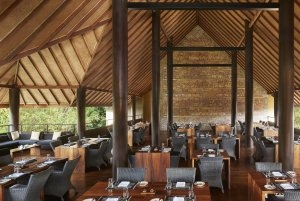 gemütliches restaurant mit gedeckten tischen im ersten stock des holzhauses und blick über die landschaft eingerichtet mit holzmöbeln