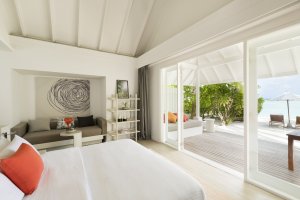helles schlafzimmer mit großem bodentiefen fenster zur terrasse und ausblick zum strand