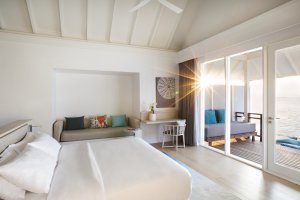 heller schlafbereich in einer villa mit großen fenstern direkt auf die terrasse und blick auf den indischen ozean der malediven