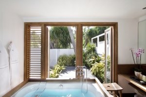 Badezimmer mit Blick nach draußen im Luxushotel Karibik Le Sereno am Strand Grand Cul des Sac