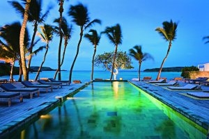 beleuchteter Pool bei Abenddämmerung im Luxushotel Karibik Le Sereno am Strand Grand Cul des Sac