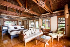 Luxus Schlafzimmer eines Garden Beachfornt und Beachfront Bure mit viel Holz und Tageslicht des Likuliku Lagoon Resort auf Fiji