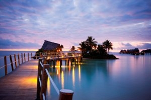 Sonnenuntergang an der Holzbrücke die zur Masima Island Bar führt unter der die Südsee in blau und lila Töne schimmert und einen wahren Traumurlaub die Kulisse gibt im Likuliku Lagoon Resort auf Fiji