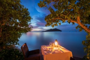 Romantisches Dinner bei Nacht an der Südsee mit Blick auf Meer im Luxushotel Likuliku Lagoon Resort