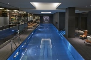 langer Pool im Luxury Spa im Mandarin Oriental Hyde Park London das sehr modern gestaltet wurde und in dunklen tönen gehalten ist