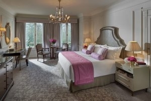 Schlafzimmer des Mandarin Oriental Hyde Park mit viel Chichi und hellen Stoffen in London