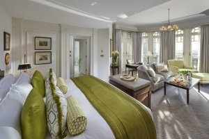 Schlafzimmer und Wohnbereich einer suite Turret im Mandarin Oriental Hyde Park mit hellen Stoffen und in sanftem grün gehaltenen Akzenten