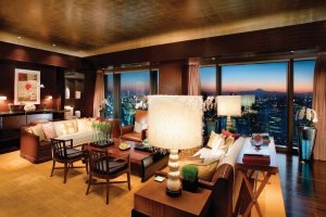 großes Wohnzimmer der Presidential Suite im Mandarin Oriental Tokyo mit Sofa einer Bar und grandiosem Ausblick auf die Stadt Tokio