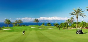 golf spielen am abama golf course mit blick auf das blaue meer und golfbuggy abama golf resort teneriffa spanien
