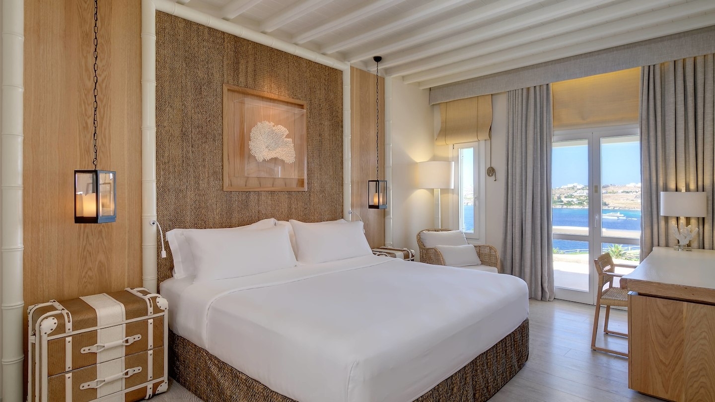 foto zimmer mit grossen weissen bett und grosser terrassentür mit meerblick und vorhängen davor im luxuriösen hochklassigen exklusiven designer hotel santa marina auf mykonos in griechenland europa