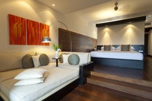 modernes schlafzimmer mit dunklem holzboden und orangen akzenten und großem bett