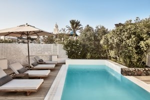 moderner geradliniger pool auf der großen terrasse der presidenten villa und hochwertigen sonnenliegen und großem sonnenschrim
