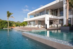blick über den großen pool vor der luxus villa neo mit sonnendeck und gemütlichen liegen in der privaten villa