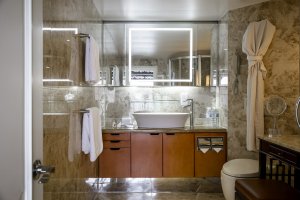 badezimmer mit braunen holzvertäfelungen vor dem waschbecken und viel licht auf dem luxus kreuzfahrt schiff in china