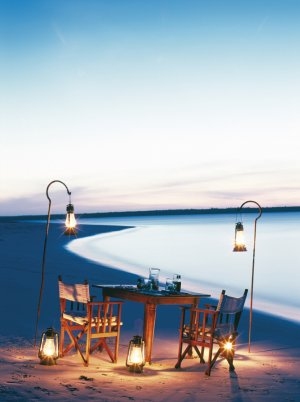 Romantisches Dinner am Strand der Mnemba Island Lodge mit Öllampen umringt biete eine einmalig romantische Stimmung direkt am Meer