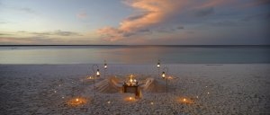 Romantisches Dinner am Strand der Mnemba Island Lodge mit Kerzen und Fackeln beleuchtet biete eine einmalig romantische Stimmung zum Sonnenuntergang