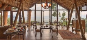 Restaurant in der Ngorongoro Crater Lodge mit großen Fenstern und Blick über die einmalige Natur Tanzanias lässt das Frühstück zum puren Luxus werden