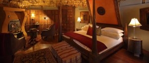 Bett in der Ngorongoro Crater Lodge ihrer Luxuslodge Tanzania mit edler Ausstattung und wohnlichem Flair