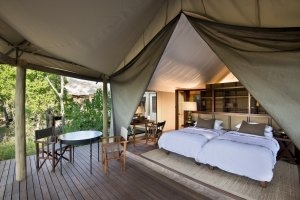 Familien Suite im andBeyond Nxabega Okavango Tented Camp mit großem bett und Terrasse in ihrem Luxusurlaub in Botswana